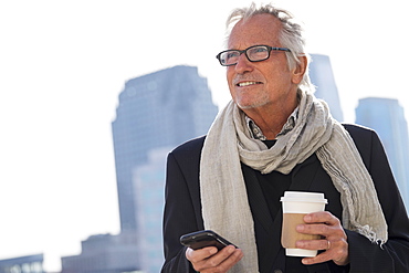 Man in street with coffee and smartphone