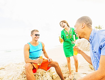 Young people drinking beer on beach, Jupiter, Florida