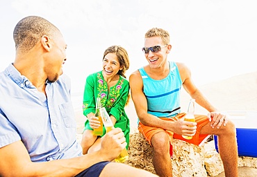 Young people drinking beer on beach