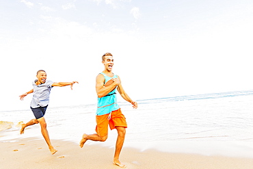 Young men playing with football on beach, Jupiter, Florida