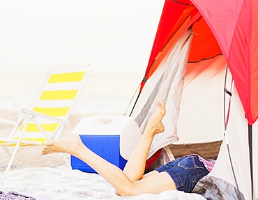 Young woman's legs sticking out from tent