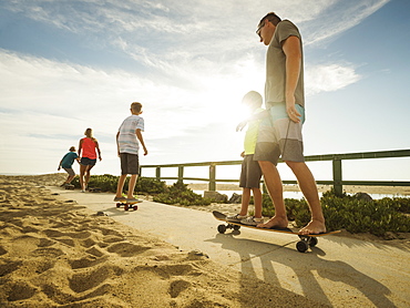 Parents skateboarding with their children (6-7, 10-11, 14-15), Laguna Beach, California