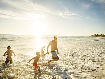 Father on beach with his three sons (6-7, 10-11, 14-15), Laguna Beach, California