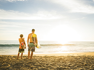 Father and son (14-15) looking at sea, Laguna Beach, California