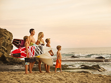 Family with three children (6-7, 10-11, 14-15) looking at sea, Laguna Beach, California