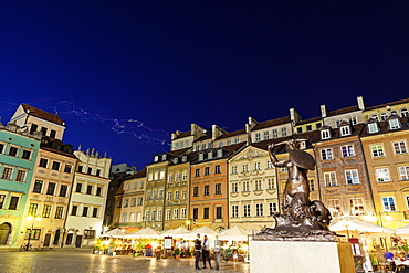 Sculpture of mermaid on town square at night, Poland