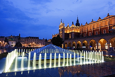 Illuminated fountain and Cloth Hall at dusk, Poland