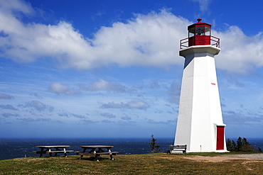 Picnic tables next to Cape George Lighthouse with sea on background, Nova Scotia, Canada