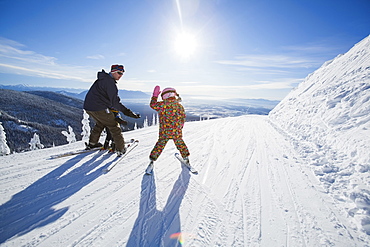 Father skiing with children (6-7, 8-9), Whitefish, Montana USA