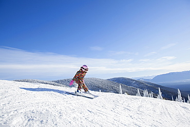 Girl (8-9) skiing in mountains, Whitefish, Montana USA