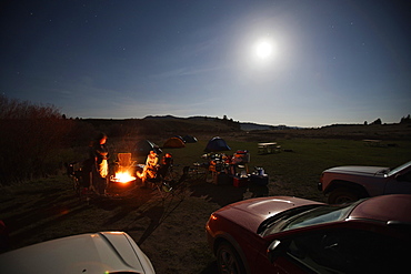 People sitting next to campfire, Smith River, Montana, USA