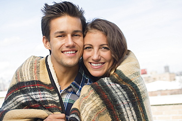 Portrait of young couple wrapped in blanket, Brooklyn, New York