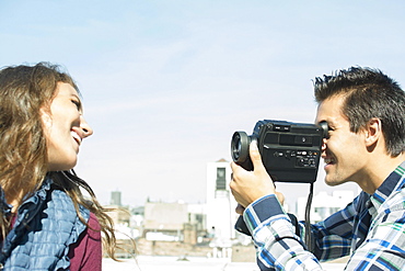 Man filming his girlfriend on roof, Brooklyn, New York