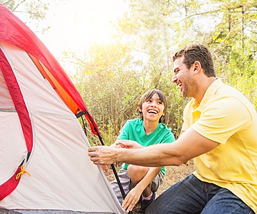 Father and son (12-13) setting up tent, Jupiter, Florida