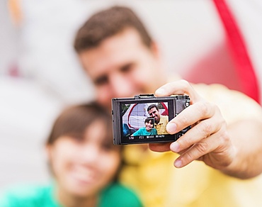 Father and son (12-13) taking selfie in front of tent, Jupiter, Florida