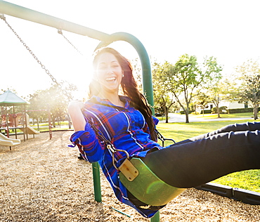 Woman swinging in playground, Jupiter, Florida