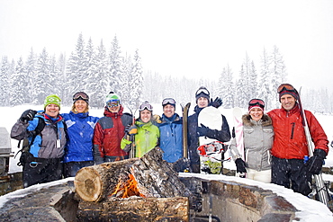 Portrait of group of friends with bonfire in winter, Whitefish, Montana, USA