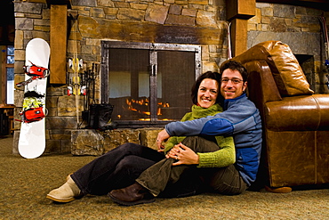 Man and woman hanging out in front of fireplace, Whitefish, Montana, USA