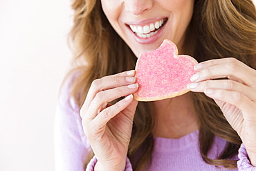 Woman holding heart shape cookie