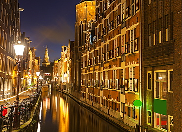 Illuminated buildings by canal at night, Amsterdam, North Holland, Netherlands