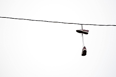 Shoes hanging in power line