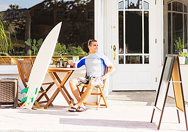 Young surfer sitting with smoothie, West Palm Beach, Florida,USA