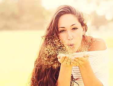 Young woman blowing confetti, Jupiter, Florida,USA