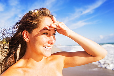 Woman on beach shielding eyes, Jupiter, Florida,USA