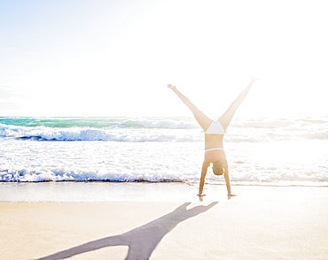 Woman doing handstand on beach, Jupiter, Florida,USA