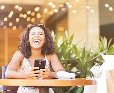 Woman using phone in cafe