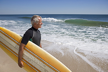 Man holding surfboard at beach