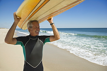 Man holding surfboard at beach