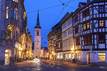 Illuminated city street and Allerheiligenkirche bell tower, Germany, Thuringia, Erfurt, Allerheiligenkirche