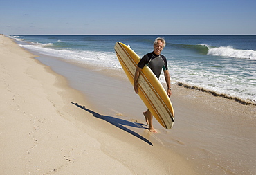 Man carrying surfboard at beach