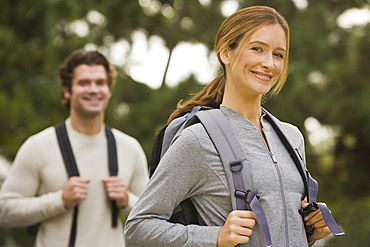 Couple wearing backpacks in woods