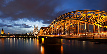 Hohenzollern Bridge illuminated at dusk, Germany, Cologne, Hohenzollern Bridge, Great St. Martin Church, Cologne Cathedral