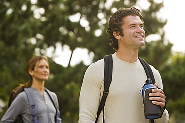 Couple wearing backpacks in woods