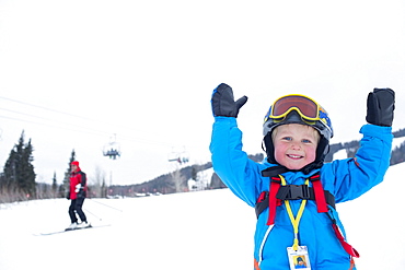 Smiley little boy (5) wearing ski suit in mountains, USA, Montana, Whitefish