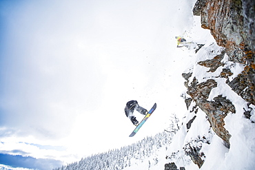 Low angle view of two men jumping from ski slope, USA, Montana, Whitefish