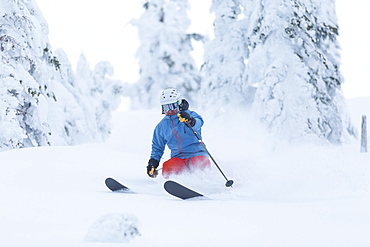 Mature man speeding on ski slope, USA, Montana, Whitefish