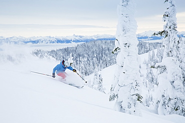 Mature man speeding on ski slope, USA, Montana, Whitefish