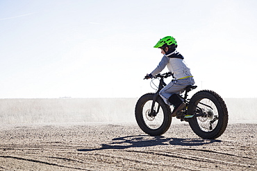 Boy (6-7) riding bicycle