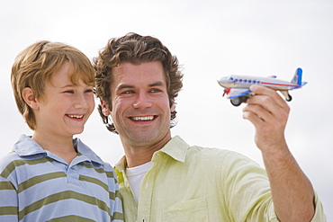 Father and son playing with toy airplane