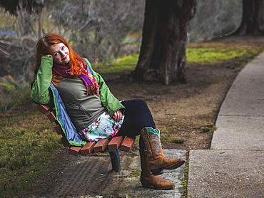 Young woman sitting on bench in park