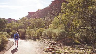 Australia, Outback, Northern Territory, Red Centre, West Macdonnel Ranges, Kings Canyon, Woman walking down mountain road