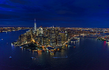 USA, New York, New York City, Manhattan, Aerial view of illuminated skyline with harbor at night