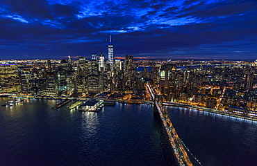 USA, New York, New York City, Manhattan, Aerial view of illuminated skyline with harbor and Brooklyn bridge at night