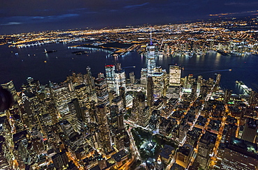 USA, New York, New York City, Manhattan, Aerial view of illuminated skyline with harbor at night