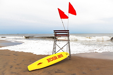 USA, New York State, New York City, Brooklyn, Yellow surfboard and empty lifeguard stand on beach