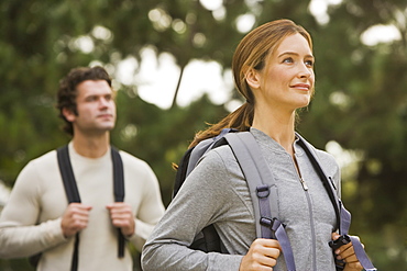 Couple wearing backpacks in woods